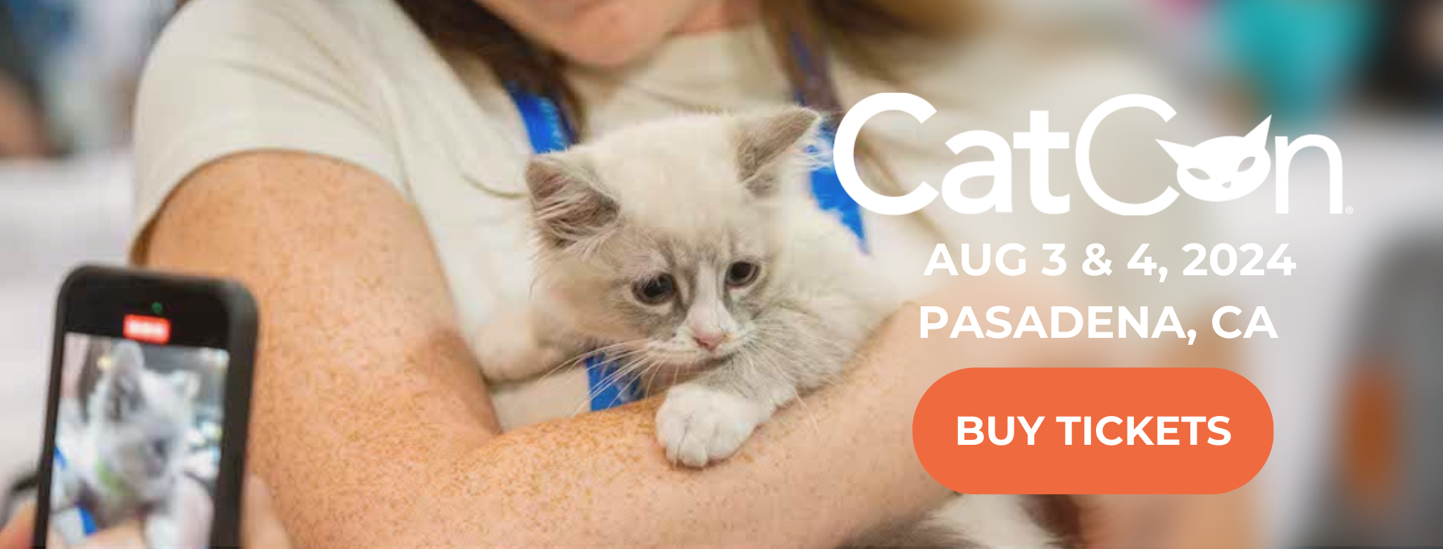 Woman holding a kitten at CatCon. BUY CATCON 2024 TICKETS NOW!