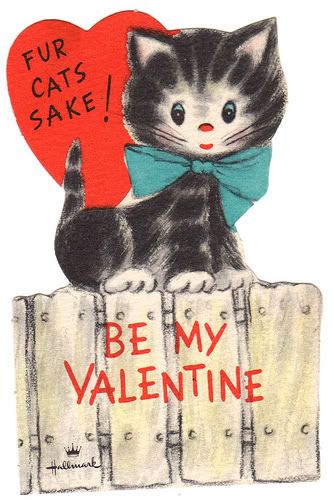 Grey cartoon cat with a blue bow around its neck and a heart in the background that reads "FUR CATS SAKE!" Cat is sitting on a fence with the words "BE MY VALENTINE"