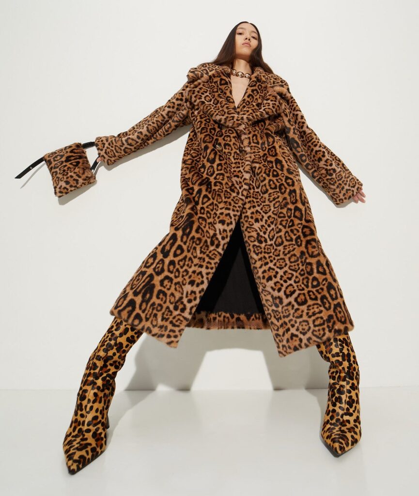 Photo of a woman in a cheetah print coat, matching purse and boots