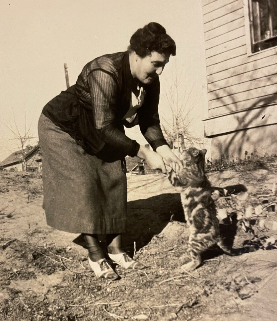 Woman playing with a cat outside, vintage cat photo