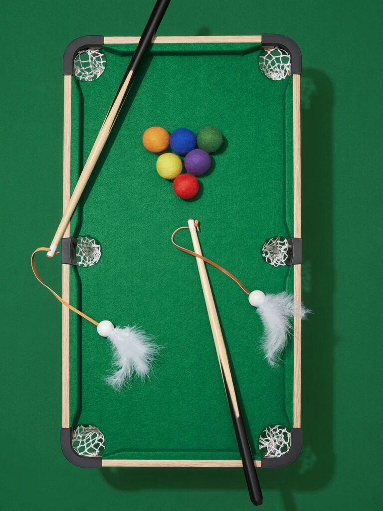 Photo of a small pool table with felt balls and cat dancers - a cat toy