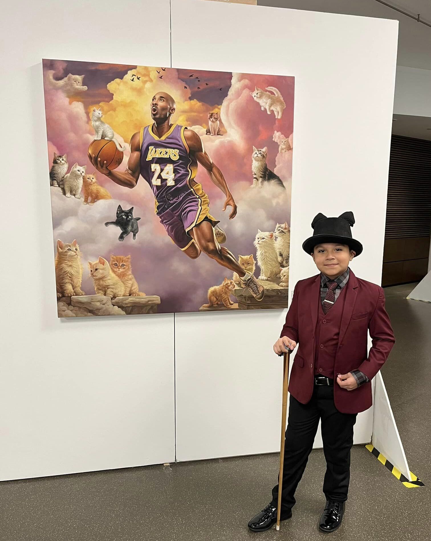 Dapper boy in front of "Kobe in the Kingdom of Kittens" at Cat Art Show